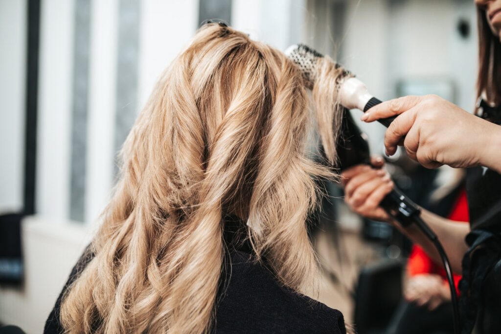 blonde lady getting her hair curled in a salon